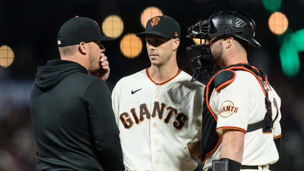 San Francisco Giants pitching coach Andrew Bailey (84) talks to relief pitcher Taylor Rogers (33) and catcher Joey Bart (21) against the Los Angeles Dodgers.